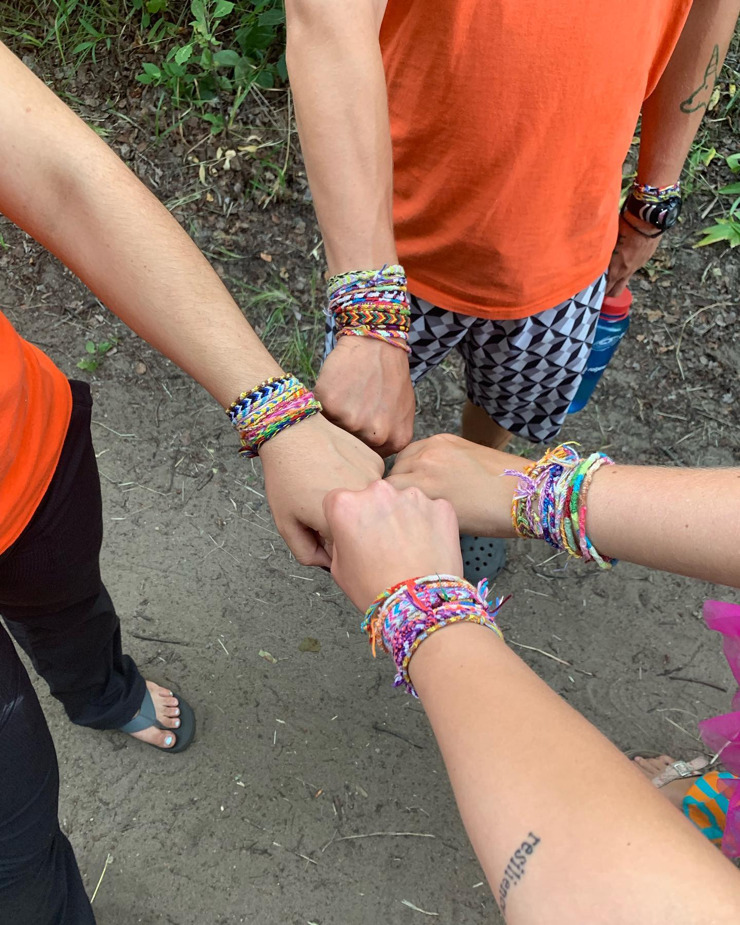 four fists with friendship bracelets
